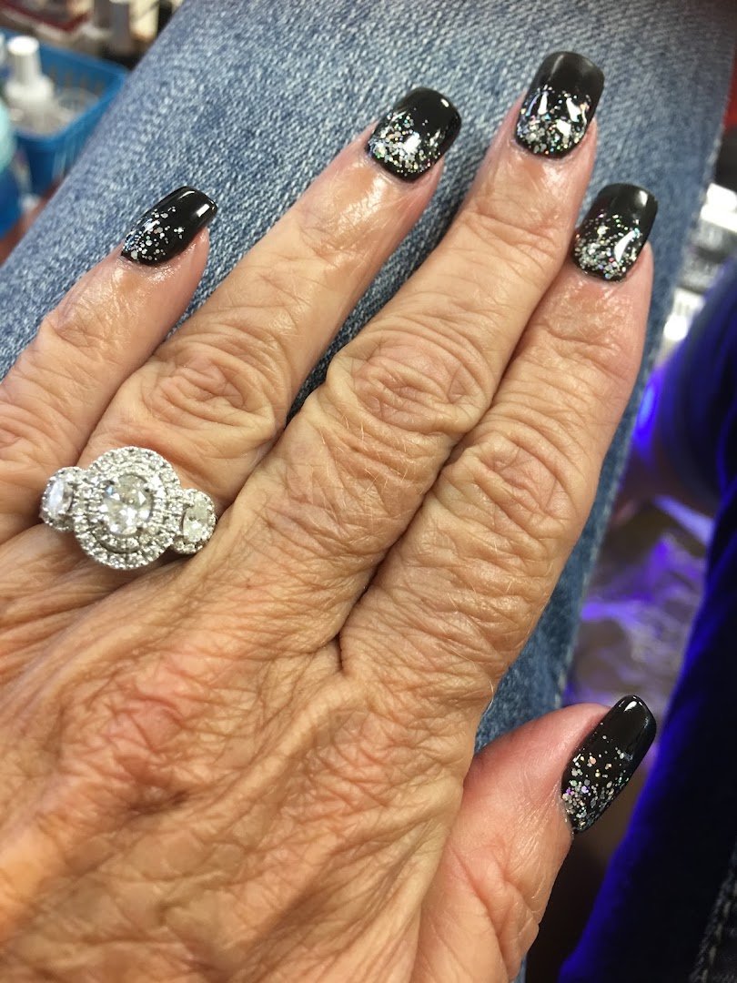 Nail technician shaping an almond manicure.
